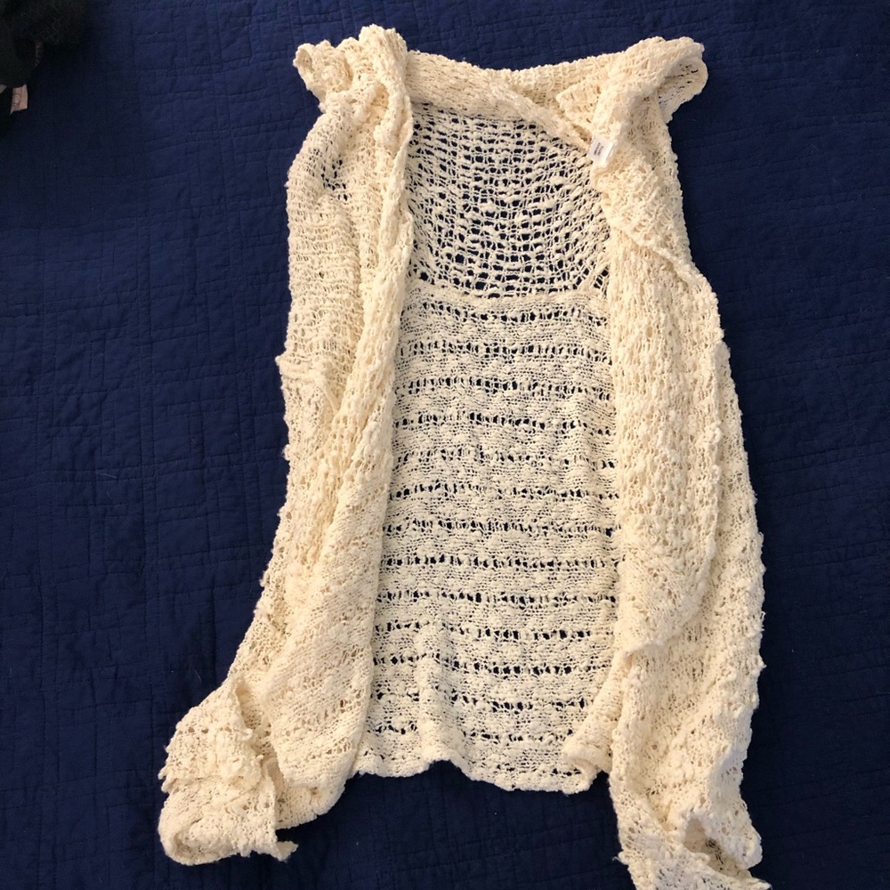 Off-white sleeveless cardigan. Can be worn 2 ways